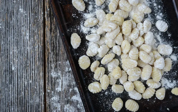 Gnocchi a Cookie lapon és rusztikus, fából készült háttér — Stock Fotó