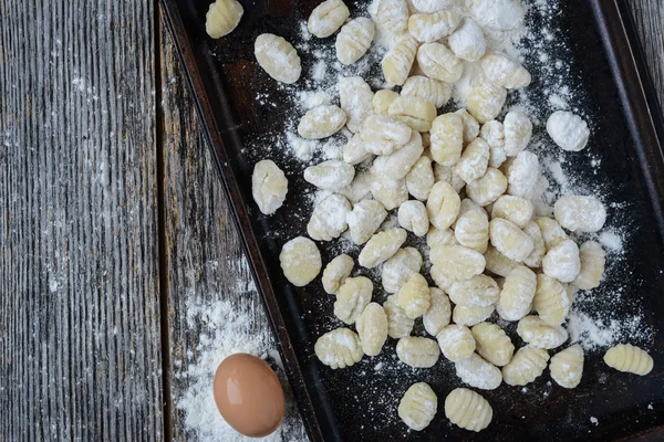 Gnocchi a Cookie lapon és rusztikus, fából készült háttér — Stock Fotó