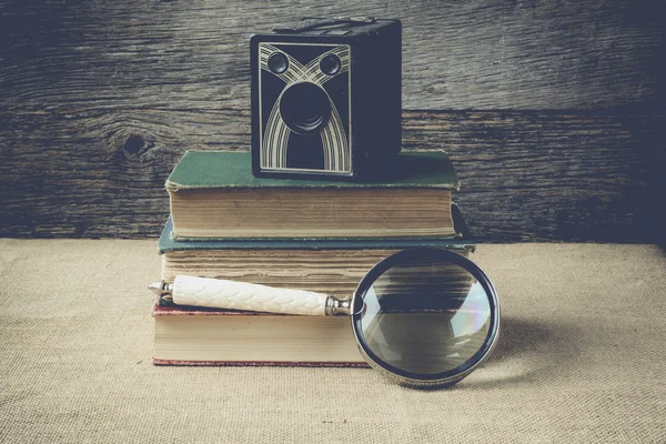 Books, camera, and magnifying glass on retro background with Ins — Stock Photo, Image