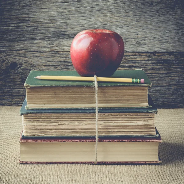 Bücher und Apfel auf Retro-Hintergrund mit Instagram-Filter — Stockfoto