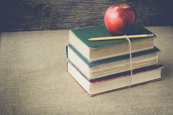 Bücher und Apfel auf Retro-Hintergrund mit Instagram-Filter — Stockfoto