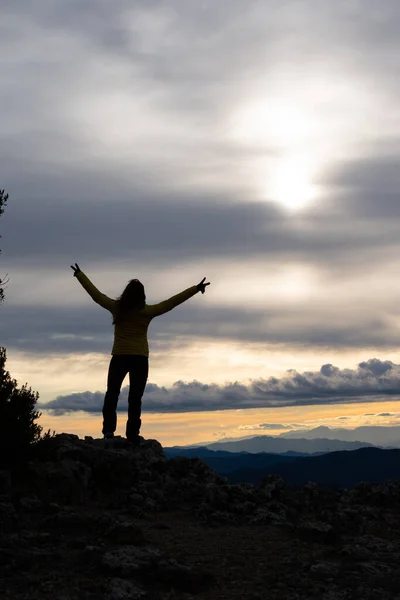 Dağın tepesinde bir kadının silueti.