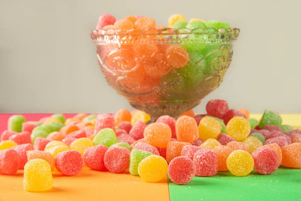 Gummy candy, arrangement of gummy candy seen in detail scattered on the table on a colored surface.