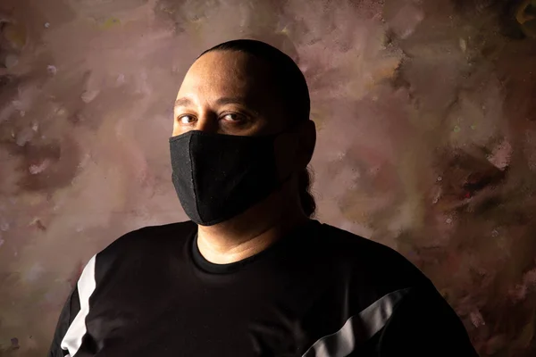 Portrait of brazilian man wearing mask against covid-19, abstract background, selective focus