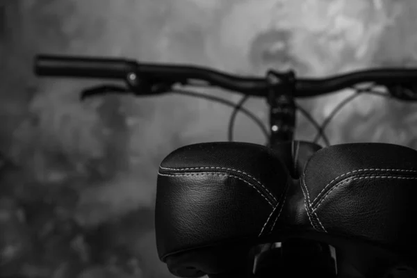 Bicycle details, seat details and handlebars, dark abstract background, selective focus.