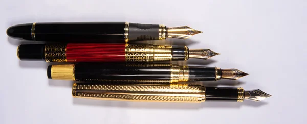 Fountain pen, four beautiful fountain pens in detail on white background, top view.