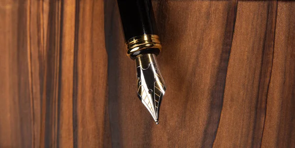 Fountain pen, beautiful fountain pen in detail on rustic wood, selective focus.