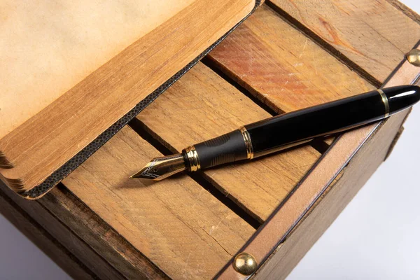 Fountain pen, beautiful fountain pen in detail on rustic wood and an old book, selective focus.