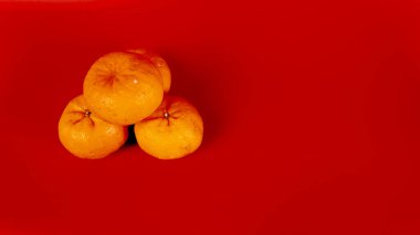 Çin Yeni Yıl kutlamaları için 5 Mandarin portakalı ve kırmızı arka planda süsleme