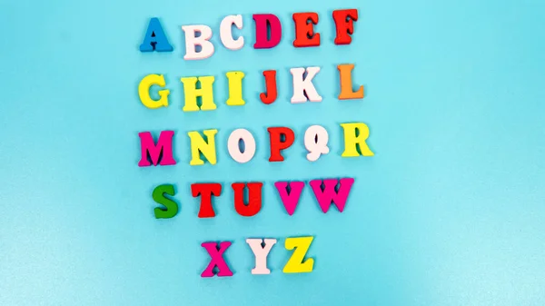 Selective focus of an alphabet letters isolated on blue background.