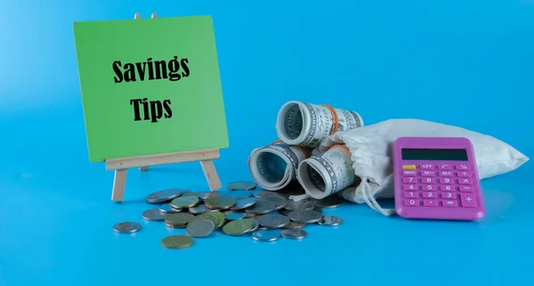 Money saving tips concept. Selective focus on the green board  with a text saving tips. How to save money fro holiday, paying loan or investment concept