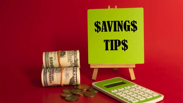 Money saving tips concept. Selective focus on the green board  with a text saving tips. How to save money fro holiday, paying loan or investment concept