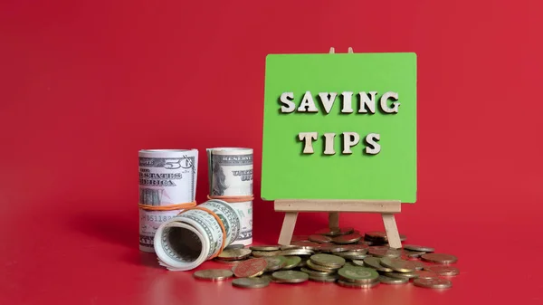 Money saving tips concept. Selective focus on the green board  with a text saving tips. How to save money fro holiday, paying loan or investment concept