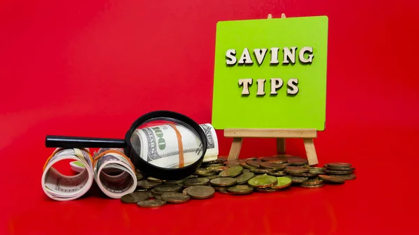 Money saving tips concept. Selective focus on the green board  with a text saving tips. How to save money fro holiday, paying loan or investment concept