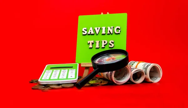 Money saving tips concept. Selective focus on the green board  with a text saving tips. How to save money fro holiday, paying loan or investment concept