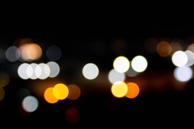 Bokeh 'teki parlak yıldızların soyut arkaplanı. Resmin altındaki turuncu bokeh. Siyah bir geçmişi var.