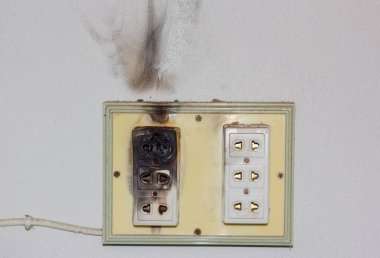 Electricity short circuit and Electrical failure resulting in electricity wire burnt on wall clipart