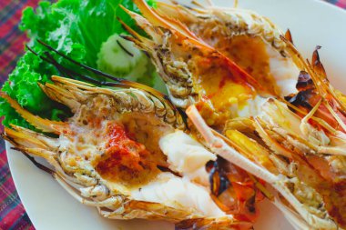 Beyaz diskte baharatlı deniz ürünleri soslu ızgara nehir devi karides..