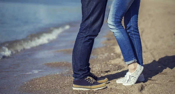 The first date concept. Young couple of hipsters wearing trendy clothing and shoes standing together on beach. Sunny day. Copy-space. Outdoor shot — Stockfoto