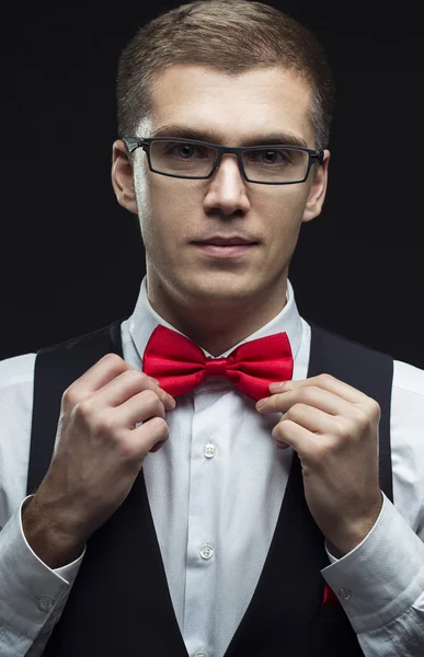 Handsome elegant young fashion man in black classical costume suit, white shirt and red bow tie — Stok fotoğraf