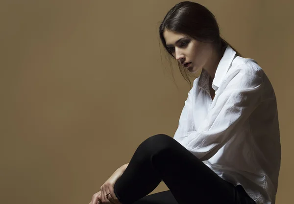 Conceito de beleza feminina. Retrato de menina na moda em roupas clássicas posando sobre fundo marrom. Cabelo perfeito & pele. Estilo Vogue. Estúdio — Fotografia de Stock