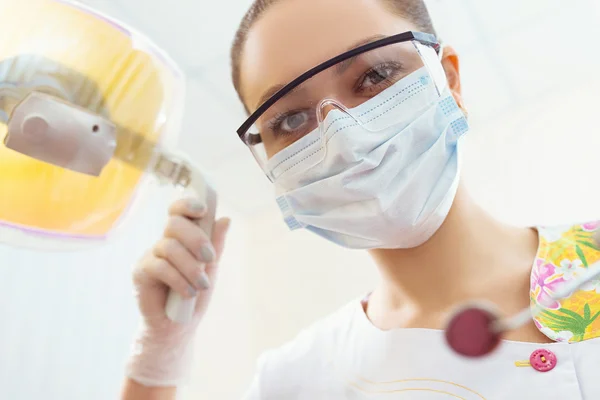 Portrait of a surgeon at work.Orthodontic Treatment. Dental care Concept. Dental inspection is being given to  Beautiful Woman surrounded by dentist and his assistant. — Stockfoto