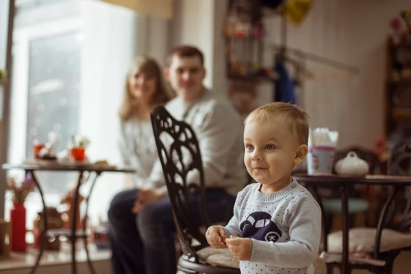 Retrato de uma jovem família feliz tomando café da manhã no café. Conceito da família feliz e tempo engraçado juntos — Fotografia de Stock