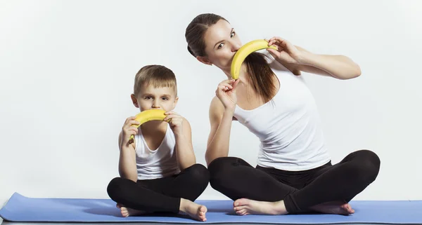 Mãe e filho fazendo ioga (exercícios esportivos), se divertir e passar um bom tempo juntos. isolado em branco. o conceito de um estilo de vida saudável — Fotografia de Stock