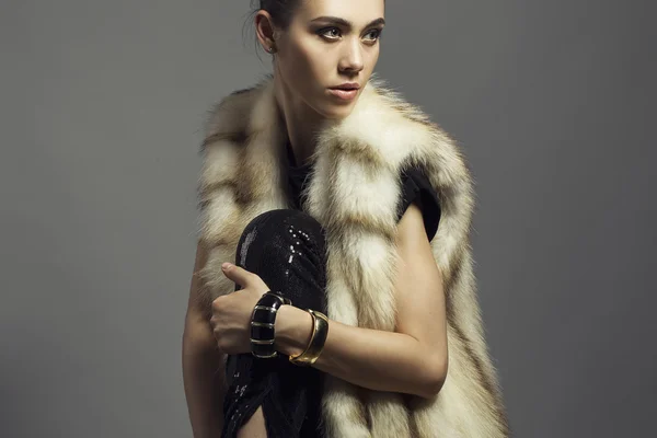 Sexy Beauty Girl with natural  Make up.  Fashion Brunette Portrait of a girl dressed in fur coat and black shirt posing on a grey background. Retro style — Stock Photo, Image