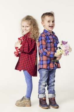 Komik çok güzel çocuklar. moda erkek ve kız kot pantolon ve ekose gömlek. küçük çocuk kıza çiçek verir. şık çocuklar rahat ayakkabı. moda çocuk