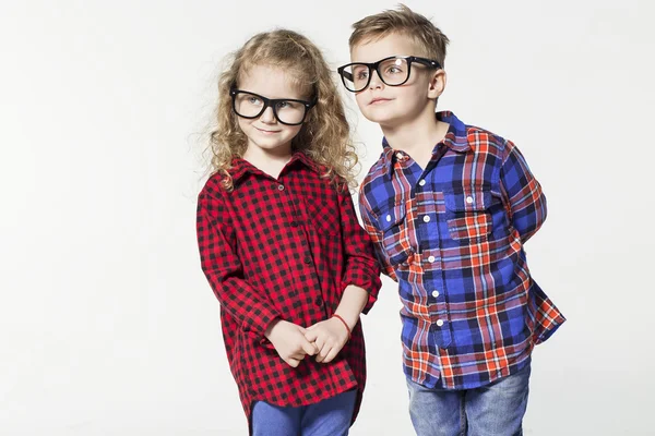 Engraçado crianças encantadoras. menino e menina na moda em óculos, jeans, camisetas brancas e xadrez crianças shirts.stylish em sapatos casuais. moda crianças — Fotografia de Stock