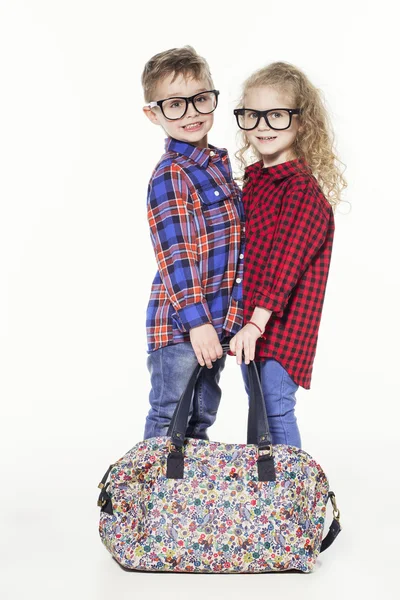 Lustige, liebenswerte Kinder. modische kleine Jungen und Mädchen in Brille, Jeans, weißen T-Shirts und karierten Hemden. Stilvolle Kinder in lässigen Schuhen. Modekinder — Stockfoto