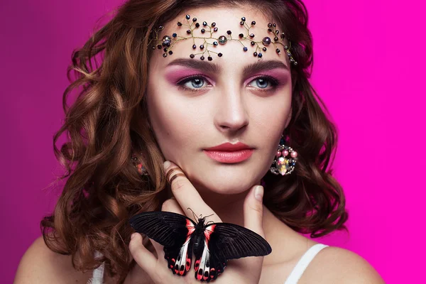 Studio beauty portrait with red butterfly. Portrait of beautiful young woman with perfect spring makeup, with jewels on the face. — Stockfoto