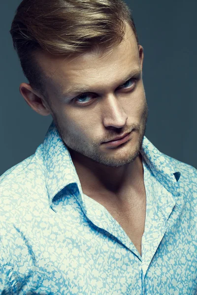 Male beauty concept. Portrait of fashionable hipster young man with stylish haircut posing over grey background. Perfect hair & skin. Tough guy. Vogue style. Close up. Studio shot — Stock Fotó