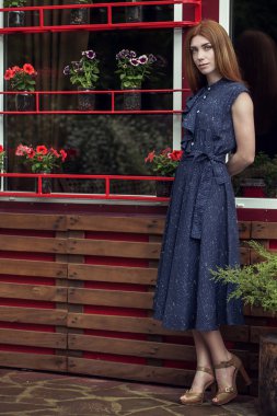 Güzel şık genç kız rahat kıyafetler (elbise ve spor ayakkabı) giyinmiş yağmur sonrası kentin sokaklarında yürüyor. Kadınlar için moda giyim kavramı