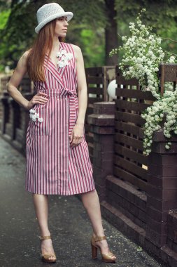 Güzel şık genç kız rahat kıyafetler (elbise ve spor ayakkabı) giyinmiş yağmur sonrası kentin sokaklarında yürüyor. Kadınlar için moda giyim kavramı