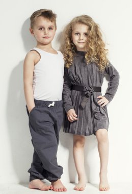 Komik çok güzel çocuklar. Moda erkek ve kız gri ve beyaz giysiler ve yalınayak. farklı duygular ile rahat kıyafetler şık çocuklar. moda çocuk