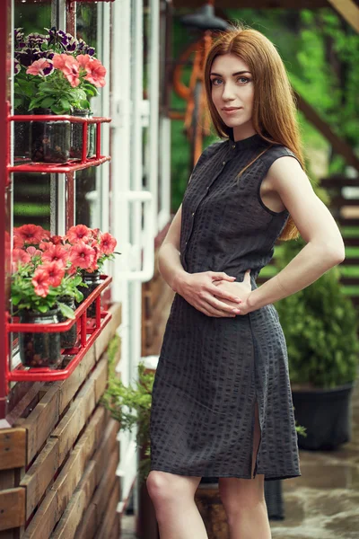 Belle jeune fille élégante vêtue de vêtements décontractés (robe et baskets) se promène dans les rues de la ville après la pluie. le concept de vêtements de mode pour femmes — Photo