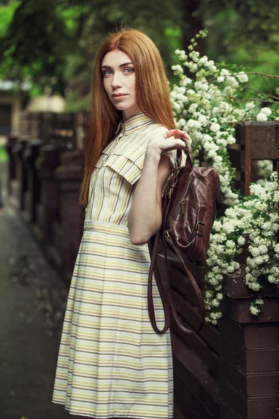Красивая стильная молодая девушка в повседневной одежде (платье и кроссовки) гуляет по улицам города после дождя. концепция модной одежды для женщин — стоковое фото