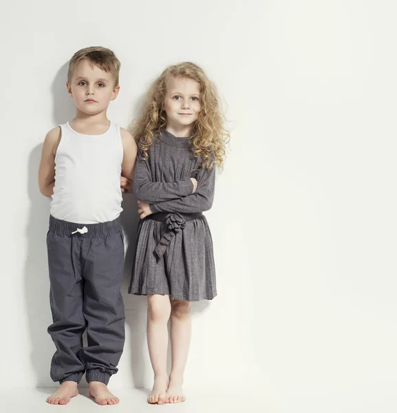 Lustige, liebenswerte Kinder. Modische kleine Jungen und Mädchen in grau-weißen Kleidern und barfuß. stylische Kinder in lässiger Kleidung mit unterschiedlichen Emotionen. Modekinder — Stockfoto