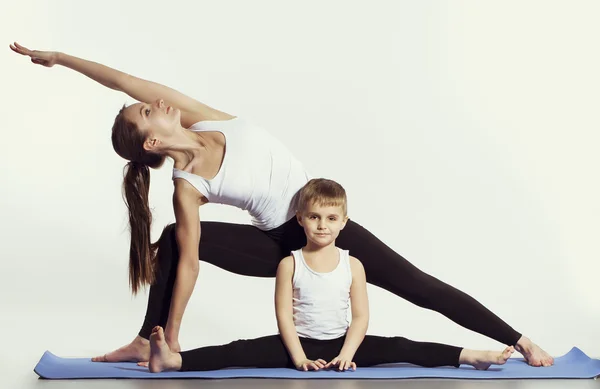 Anne ve oğlu (spor egzersizleri), yoga yaparken eğlenmek ve birlikte iyi vakit geçirmek. beyaz izole. sağlıklı bir yaşam tarzı kavramı — Stok fotoğraf
