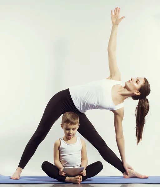 Madre e hijo haciendo yoga (ejercicios deportivos), divertirse y pasar un buen rato juntos. aislado en blanco. el concepto de un estilo de vida saludable — Foto de Stock