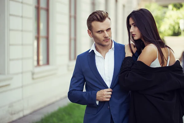 Junge glückliche modische Paar in der Stadt in stilvollen Kleidung.der Mann trägt in Business-Anzug, die Frau in romantischen sexy Kleid mit Spitze und Mantel — Stockfoto