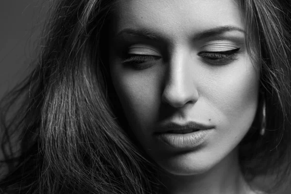 Emotive portrait of a fashionable model with curly hair and nature make-up posing over grey background. Perfect healthy skin. — Stock Photo, Image