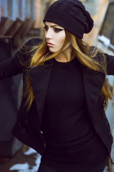 Emotionales Porträt einer schönen Frau mit langen lockigen Haaren und dunklem Abend-Make-up, die eine schwarze Jacke trägt. — Stockfoto