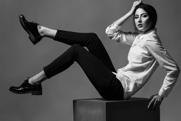 Concept de beauté féminine. Portrait de jeune fille à la mode en vêtements classiques posant sur fond d'or. Cheveux et peau parfaits. Style vogue. Plan studio — Photo