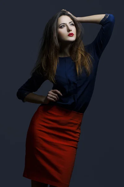 Tampilan fashion tinggi. Potret model modis dengan bibir merah seksi, rok merah yang indah dan kemeja biru. Tutup. Rekaman studio — Stok Foto