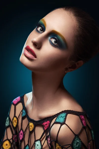 Close-up of beautiful female face with colorful make-up.Beauty. Fresh glowing skin. Accessory.Flower.Blue.Art.Theater.Face art.Bright.Closeup.Portrait.Look Fashion make-upt.Fantastic Modern production