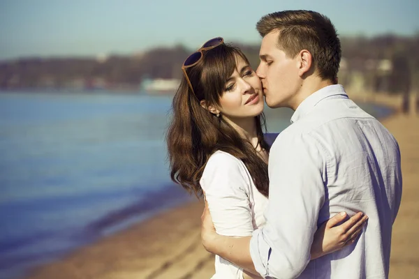 Fröhliches Paar, das sich an einem sonnigen Tag am Strand umarmt und posiert. Bild (Foto) eines glücklichen Paares, das sich am Strand amüsiert. Hipster-Stil. Außenschuss — Stockfoto