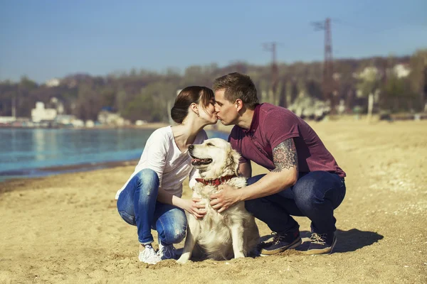 Schöne junge verliebte Paar genießen und Spaß am Strand mit ihrem Hund haben. Hipster-Stil. Außenschuss. — Stockfoto
